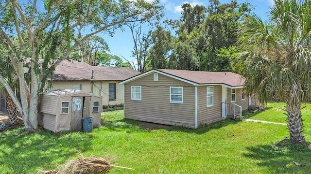 rear view of property featuring an outdoor structure and a lawn