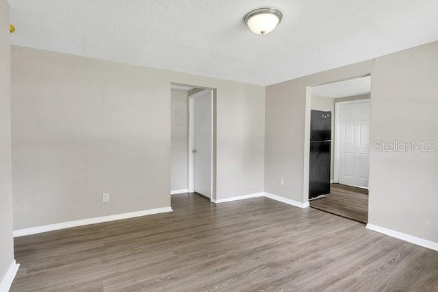 unfurnished room with wood-type flooring