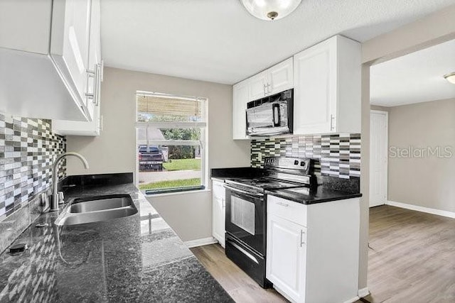 kitchen featuring white cabinets, light wood-type flooring, black appliances, and sink