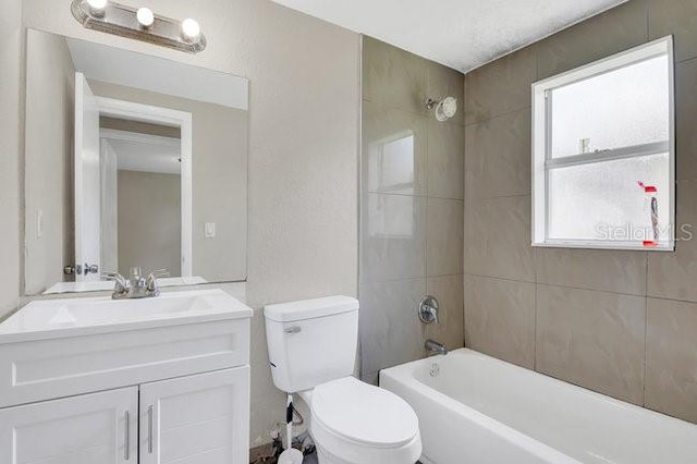 full bathroom with vanity, toilet, and tiled shower / bath