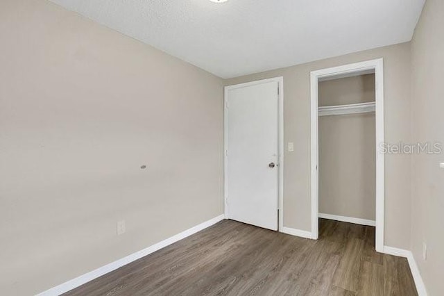 unfurnished bedroom with wood-type flooring and a closet