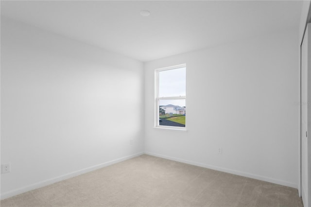 unfurnished room featuring light colored carpet