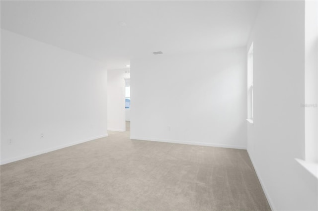 spare room featuring light colored carpet