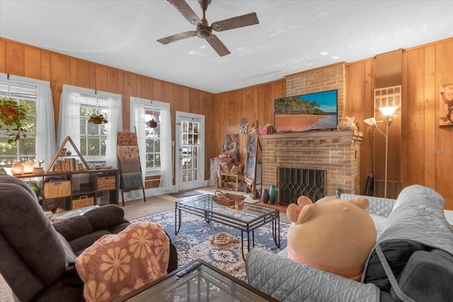 living room featuring a fireplace, wooden walls, and ceiling fan