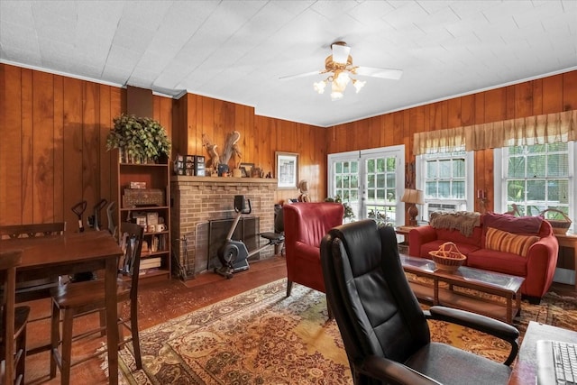 living area with wood walls and a ceiling fan