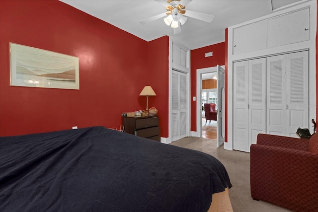 bedroom featuring carpet, ceiling fan, and two closets