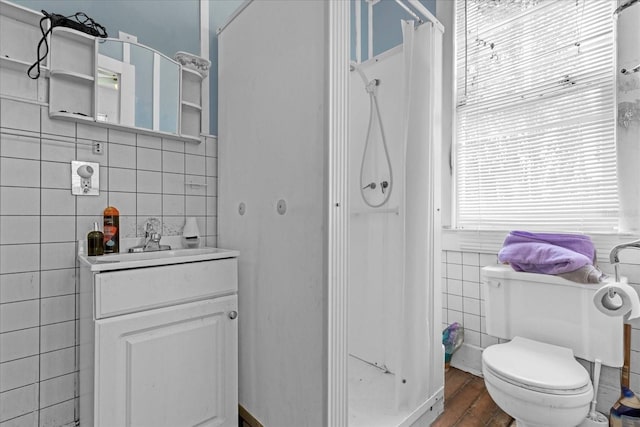 full bathroom with toilet, wood finished floors, curtained shower, vanity, and tile walls