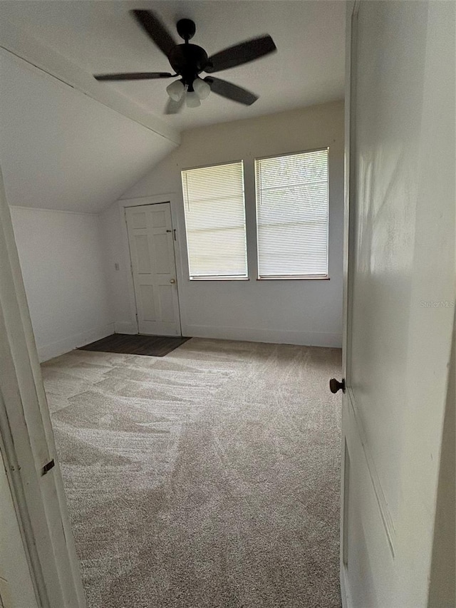 bonus room with light carpet, ceiling fan, baseboards, and vaulted ceiling