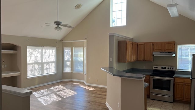 kitchen with plenty of natural light, high vaulted ceiling, light hardwood / wood-style flooring, and appliances with stainless steel finishes