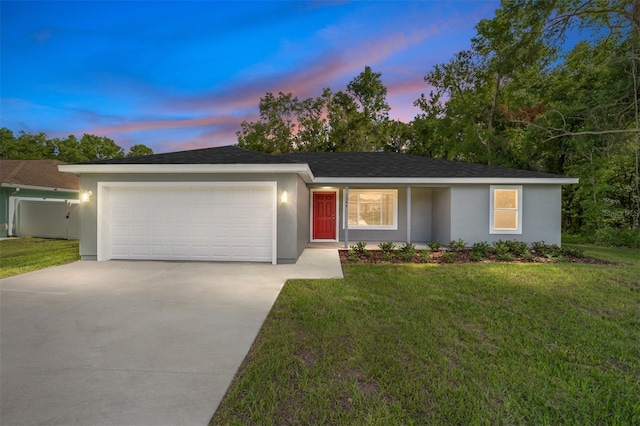 ranch-style house featuring a garage and a lawn