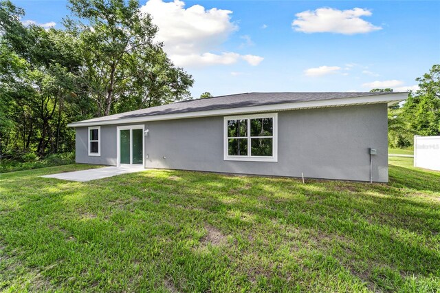 back of property with a patio and a yard