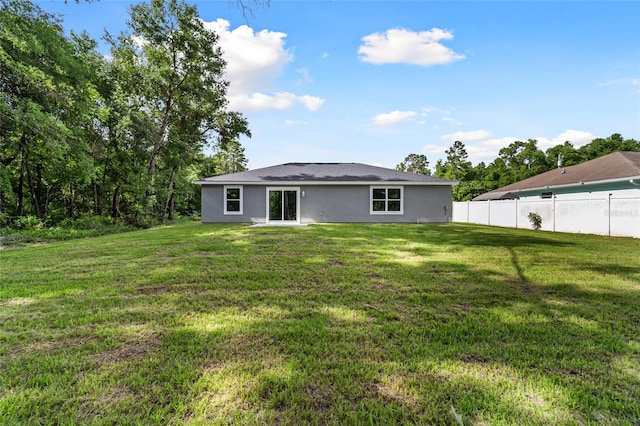 back of house with a lawn