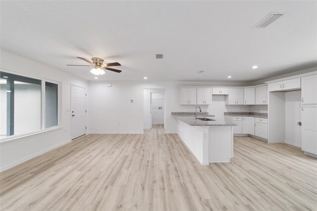 kitchen with white cabinetry, light hardwood / wood-style flooring, sink, and ceiling fan