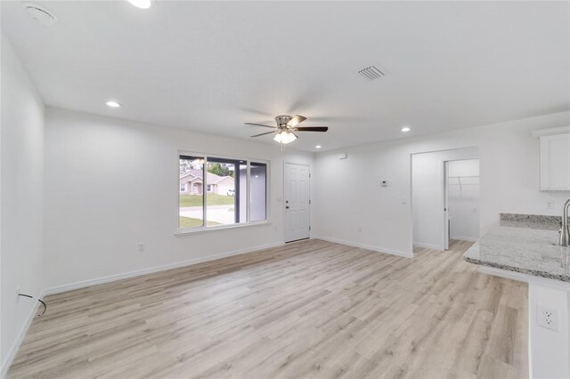 unfurnished living room featuring light wood-type flooring and ceiling fan