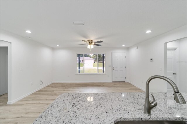 interior space with light hardwood / wood-style floors, sink, and ceiling fan