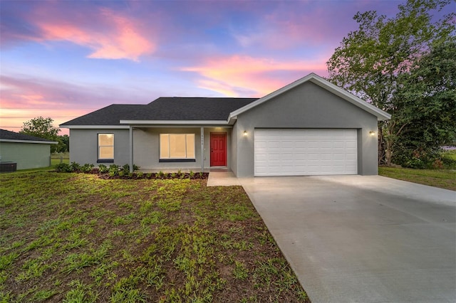 ranch-style home featuring a garage and a lawn