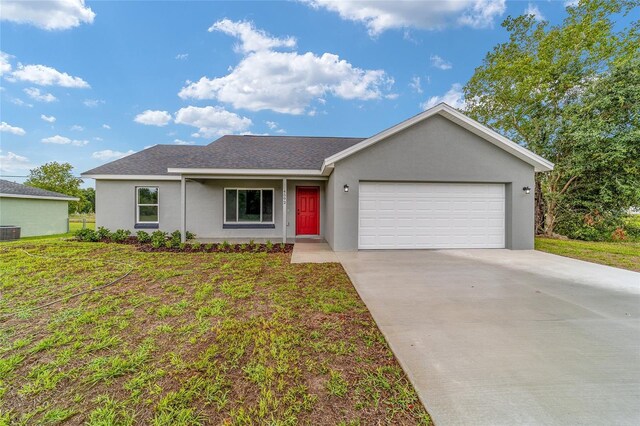 single story home featuring a garage, central air condition unit, and a front yard