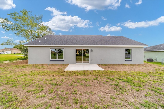 back of property with a lawn, a patio area, and central AC