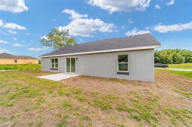 back of property with a patio area and a lawn