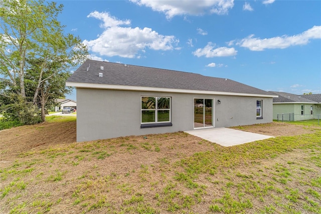 back of property featuring a patio and a yard