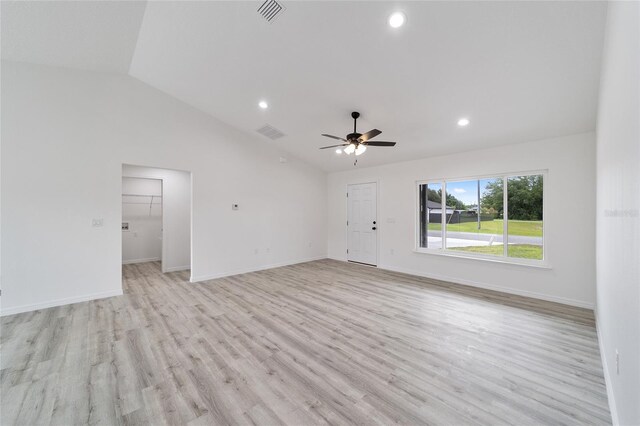 unfurnished living room with light hardwood / wood-style flooring, ceiling fan, and vaulted ceiling