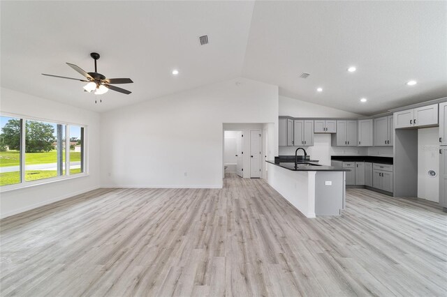 kitchen featuring gray cabinets, ceiling fan, high vaulted ceiling, light wood-type flooring, and sink