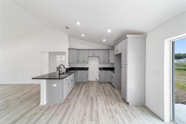 kitchen with gray cabinets, light hardwood / wood-style flooring, sink, and high vaulted ceiling