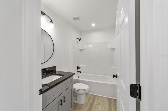 full bathroom featuring shower / tub combination, vanity, hardwood / wood-style flooring, and toilet