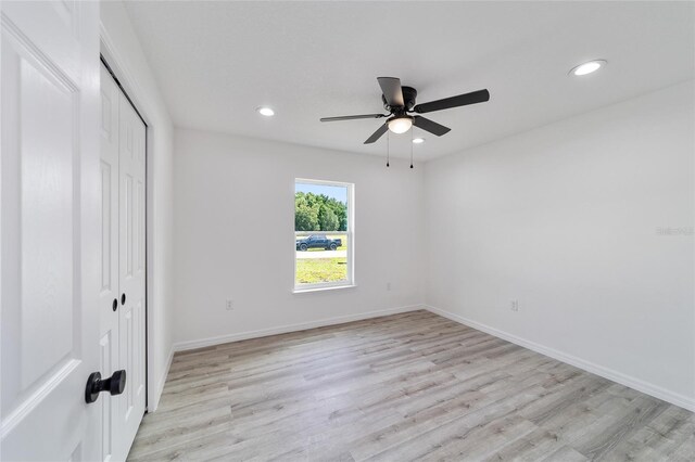 unfurnished bedroom with ceiling fan, light hardwood / wood-style floors, and a closet