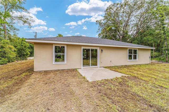 back of property featuring a patio area and a lawn