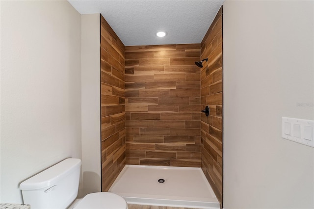 bathroom with walk in shower, a textured ceiling, and toilet