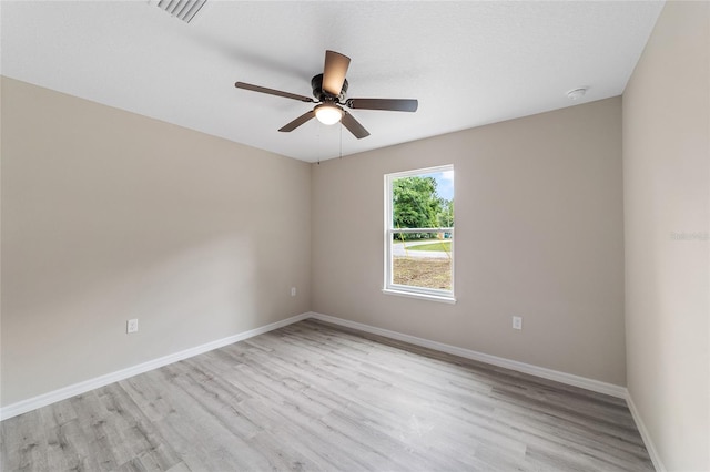 empty room with ceiling fan and light hardwood / wood-style floors