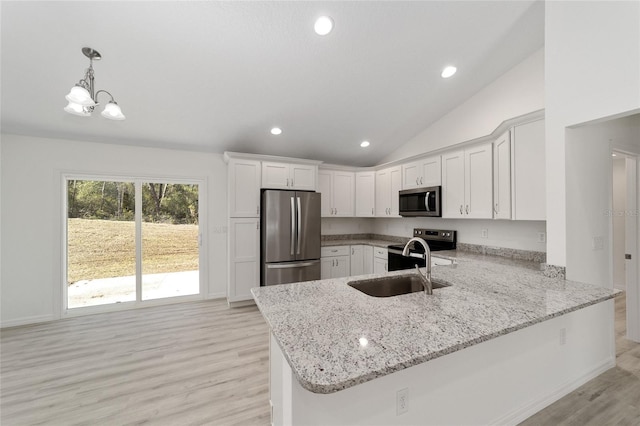 kitchen featuring kitchen peninsula, appliances with stainless steel finishes, light stone countertops, and light wood-type flooring