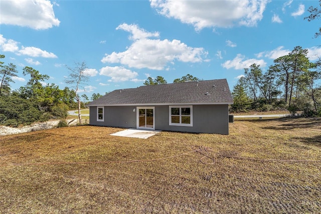 rear view of property featuring a patio and a yard