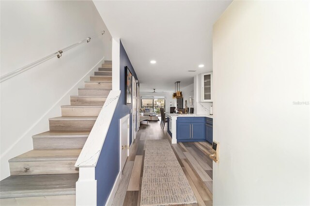 stairway with light hardwood / wood-style floors