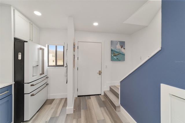 kitchen featuring high end white fridge, light hardwood / wood-style floors, blue cabinets, and white cabinets