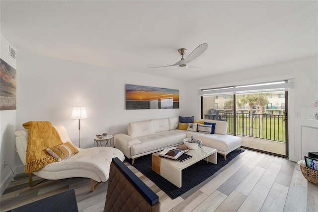 living room featuring light hardwood / wood-style flooring and ceiling fan