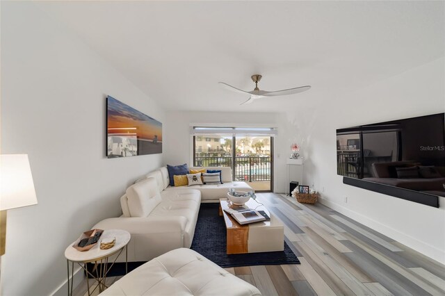 living room featuring light hardwood / wood-style flooring and ceiling fan