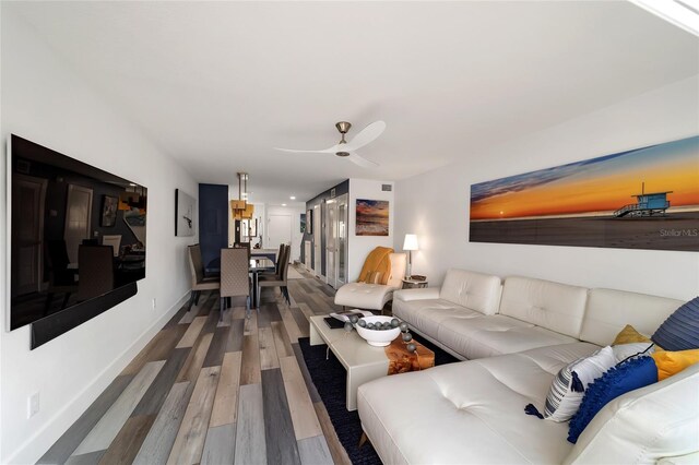 living room featuring ceiling fan and hardwood / wood-style floors