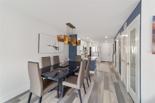 dining space with light hardwood / wood-style flooring and french doors