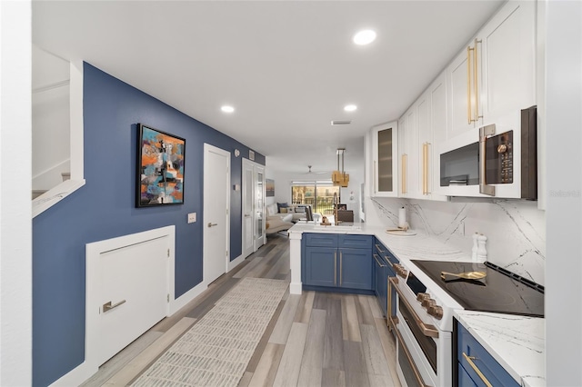 kitchen featuring range with two ovens, backsplash, white cabinetry, wood-type flooring, and blue cabinetry