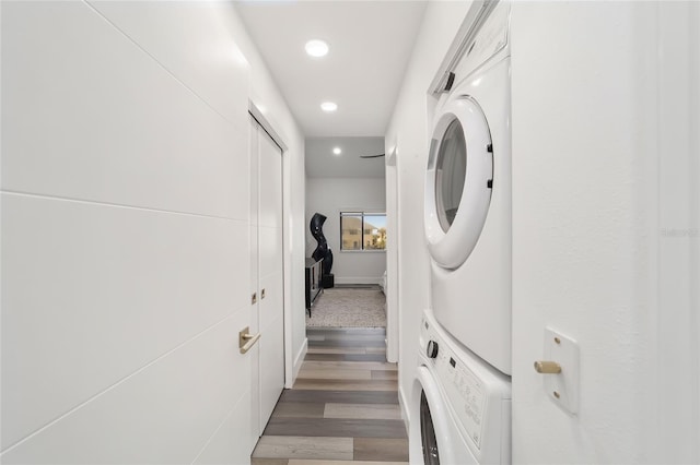 clothes washing area featuring stacked washer / dryer and dark hardwood / wood-style floors