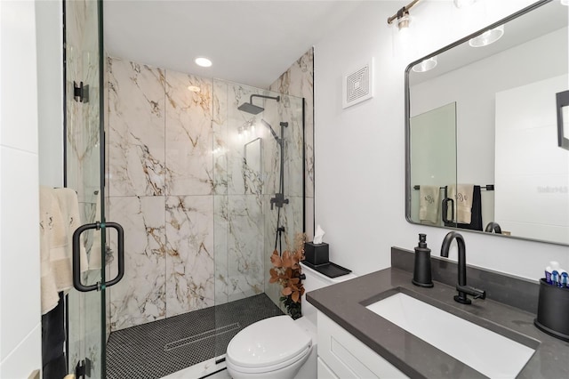 bathroom with a shower with shower door, toilet, and vanity