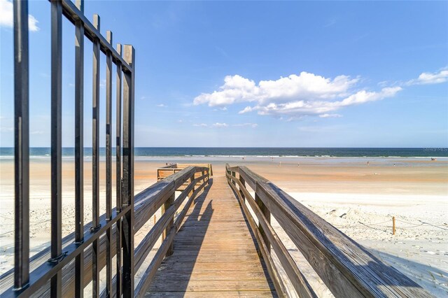 view of dock with a view of the beach and a water view