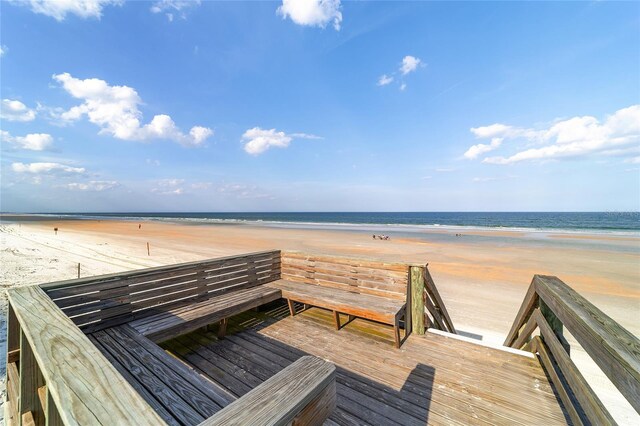 surrounding community with a view of the beach and a deck with water view