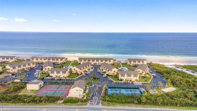 drone / aerial view with a water view and a beach view