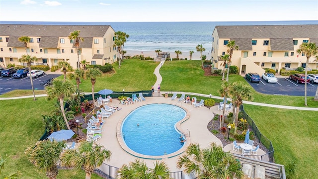 view of swimming pool featuring a yard and a water view