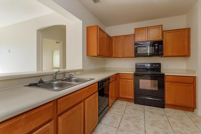 kitchen with sink, light tile patterned flooring, and black appliances