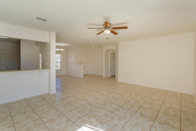 unfurnished room featuring light tile patterned floors and ceiling fan with notable chandelier