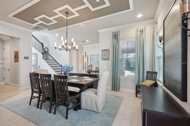 dining area featuring crown molding, a chandelier, and light hardwood / wood-style floors